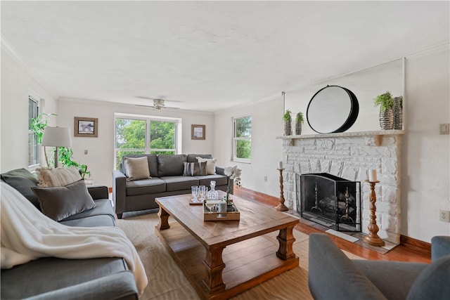 living room featuring crown molding, a fireplace, hardwood / wood-style floors, and ceiling fan