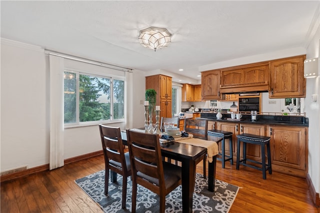 dining room featuring dark wood-type flooring and crown molding