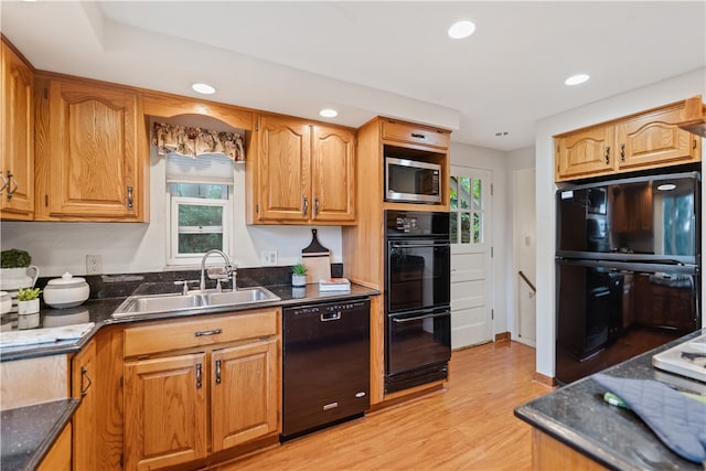 kitchen featuring light wood-type flooring, black appliances, and sink