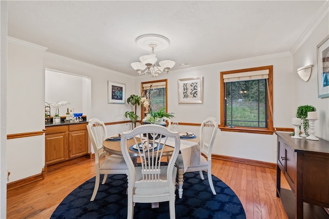 dining room featuring a notable chandelier, light wood-type flooring, and ornamental molding