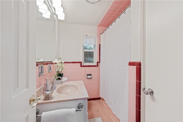 bathroom featuring a shower with shower curtain, tile walls, tile patterned flooring, and vanity