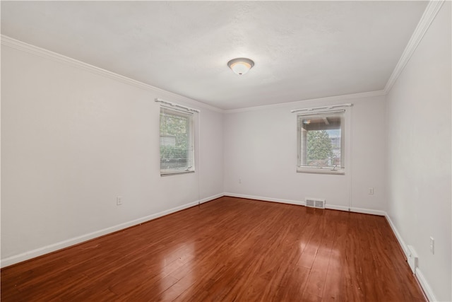 spare room with ornamental molding and hardwood / wood-style floors