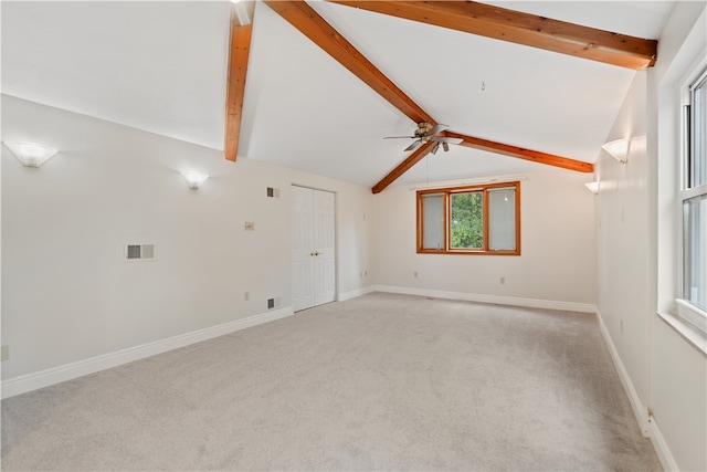 empty room with lofted ceiling with beams, ceiling fan, and light carpet