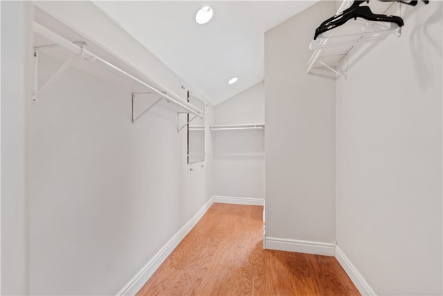 spacious closet with vaulted ceiling and hardwood / wood-style floors