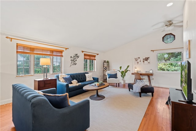 living room with a wealth of natural light, vaulted ceiling, light hardwood / wood-style floors, and ceiling fan