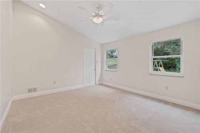 carpeted empty room featuring vaulted ceiling and ceiling fan