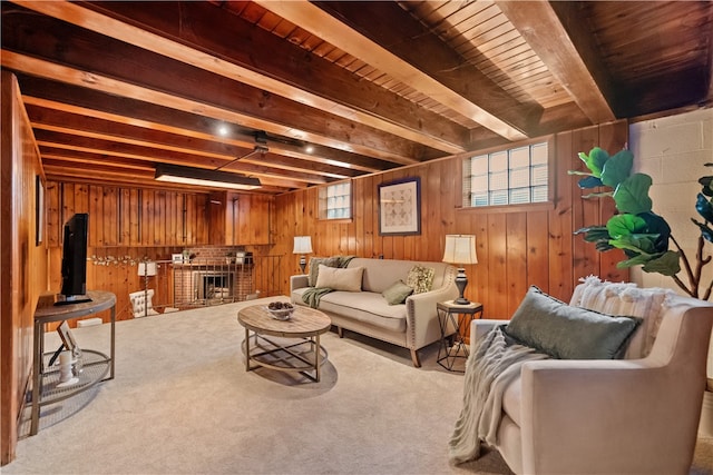 living room with a brick fireplace, beam ceiling, wood walls, and light colored carpet