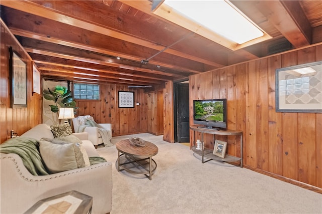 living room with wood walls, light carpet, and beamed ceiling