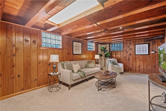 living room with light carpet, beam ceiling, and wood walls