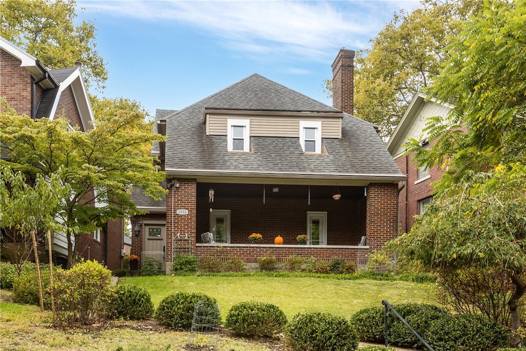 back of house with a lawn and a porch