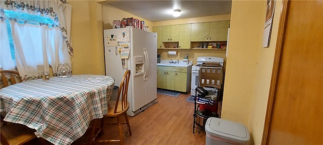 kitchen with light wood-type flooring, sink, and white appliances