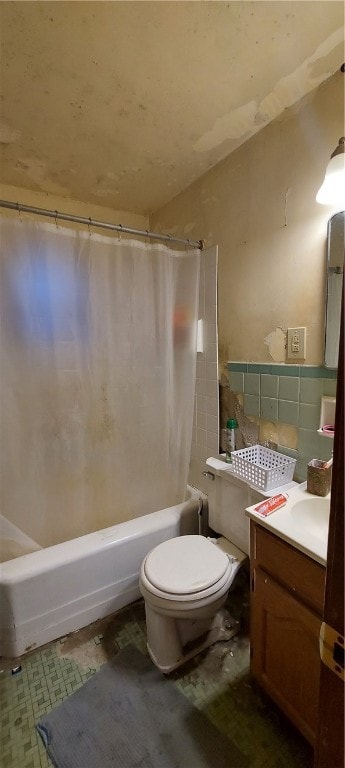 full bathroom with tile walls, shower / tub combo with curtain, vanity, and toilet