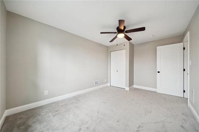 unfurnished bedroom featuring light carpet and ceiling fan