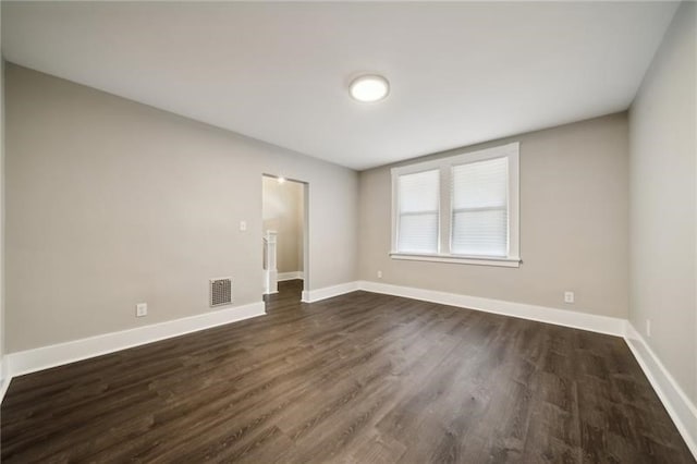 spare room with dark wood-type flooring