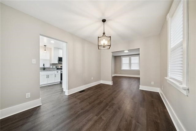 unfurnished dining area featuring sink and dark hardwood / wood-style flooring