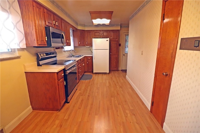 kitchen with a healthy amount of sunlight, stainless steel appliances, light hardwood / wood-style floors, and sink