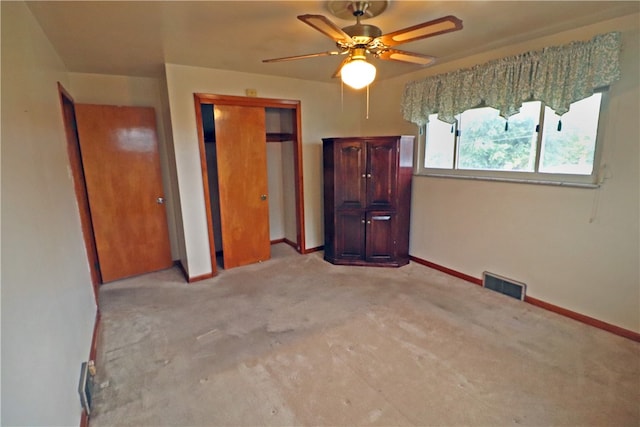 unfurnished bedroom featuring ceiling fan, light colored carpet, and a closet