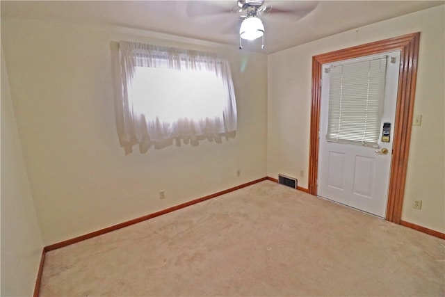 carpeted spare room featuring ceiling fan