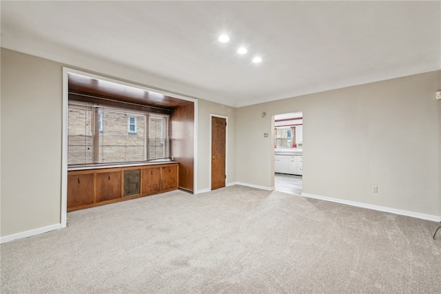 unfurnished living room with light colored carpet and plenty of natural light