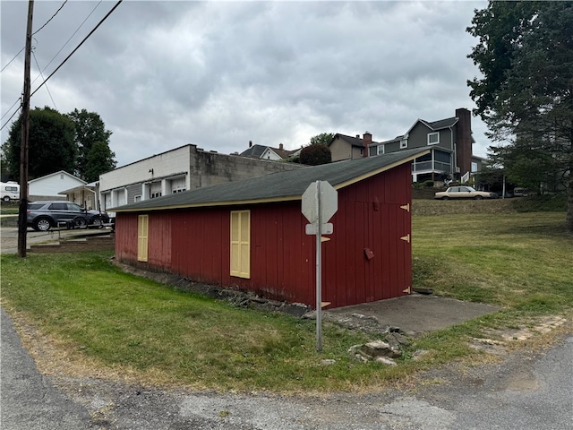 view of property exterior with a storage shed and a lawn