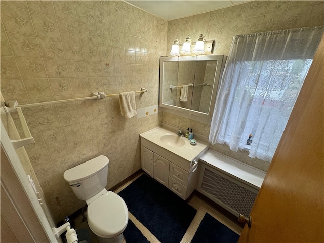 bathroom featuring radiator, vanity, tile walls, and toilet