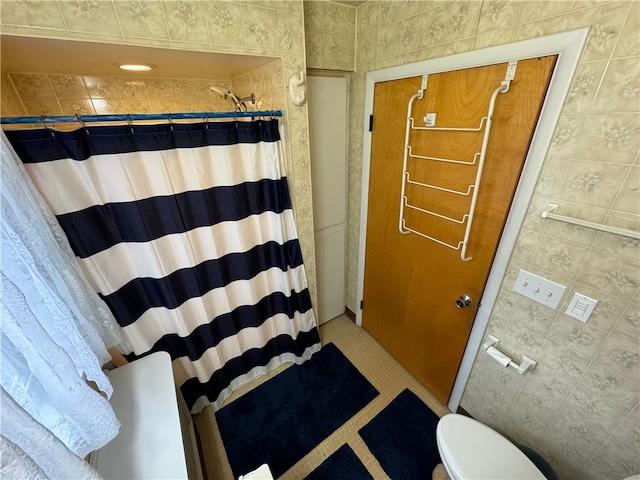 bathroom featuring tile patterned floors, toilet, tile walls, and a shower with shower curtain