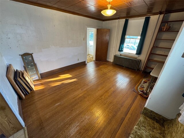 spare room featuring dark hardwood / wood-style flooring and radiator