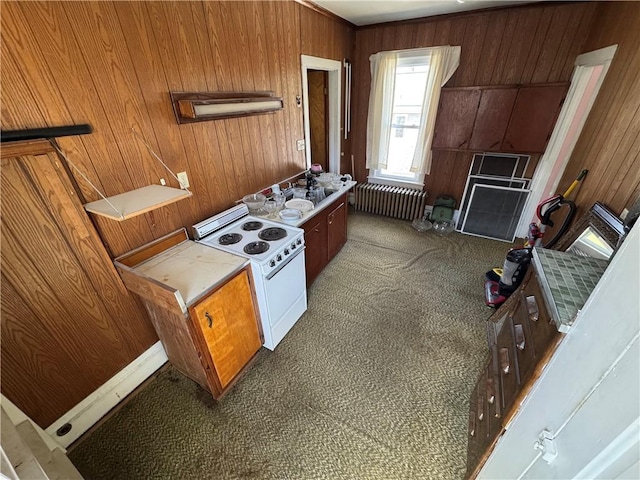 kitchen featuring radiator heating unit, wooden walls, white electric range, and carpet floors