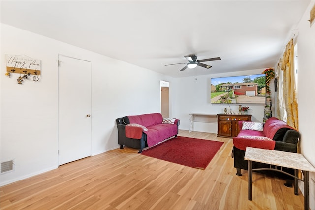 living room with light hardwood / wood-style floors and ceiling fan