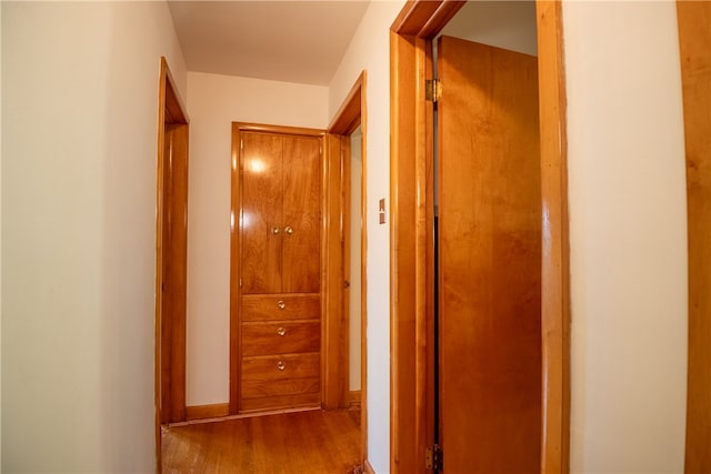 corridor with hardwood / wood-style flooring