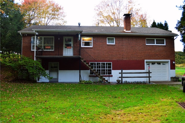 rear view of house with a yard and a garage