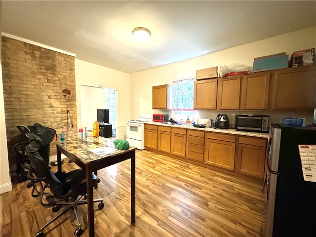 kitchen featuring light hardwood / wood-style flooring, white electric range oven, and stainless steel fridge