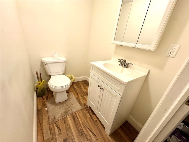 bathroom with hardwood / wood-style floors, vanity, and toilet