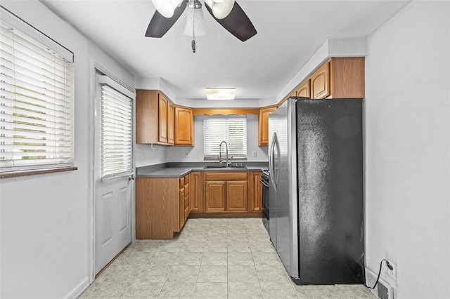 kitchen with stainless steel fridge, light tile patterned flooring, ceiling fan, black electric range oven, and sink