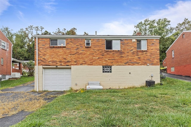 back of house featuring a garage, central AC, and a yard