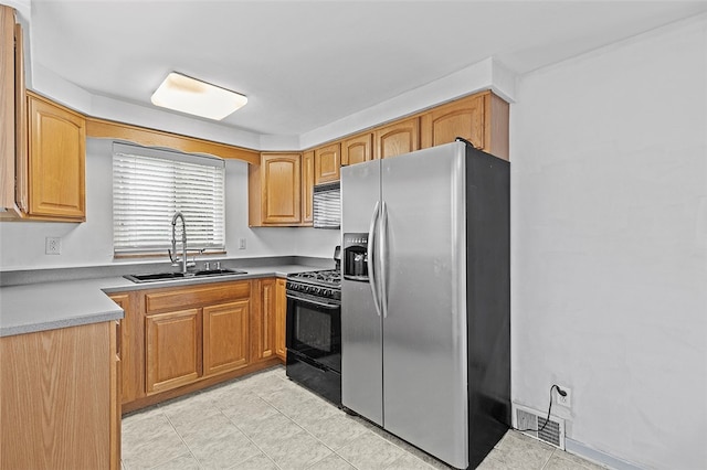 kitchen with black appliances, light tile patterned floors, and sink