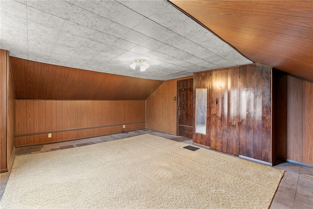 bonus room featuring wooden walls and lofted ceiling