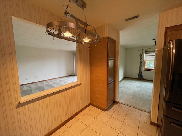 kitchen featuring light carpet and hanging light fixtures