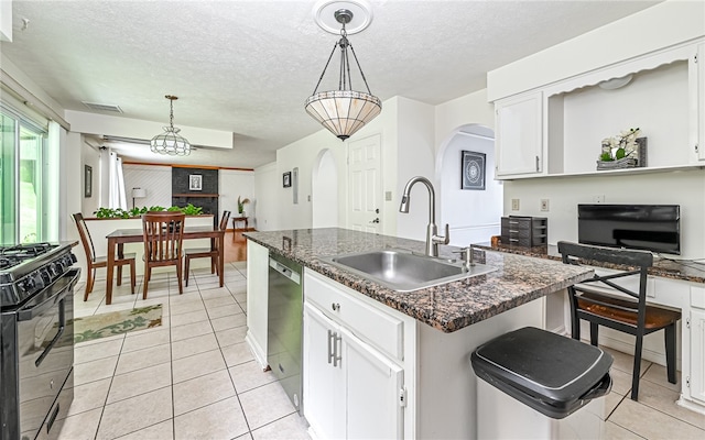 kitchen featuring pendant lighting, an island with sink, white cabinetry, dishwasher, and gas stove