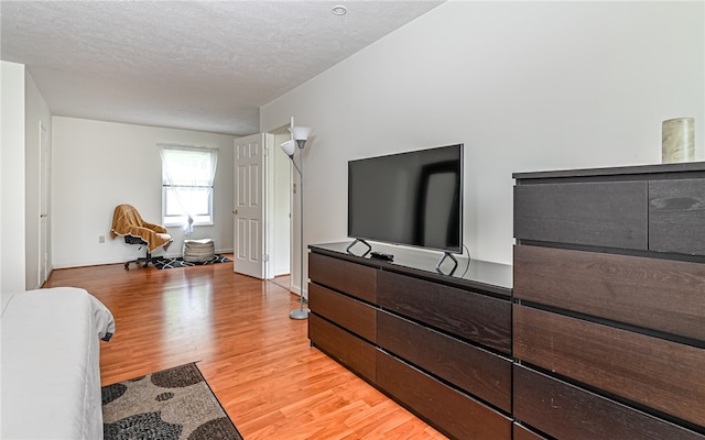 bedroom featuring a textured ceiling and light hardwood / wood-style floors