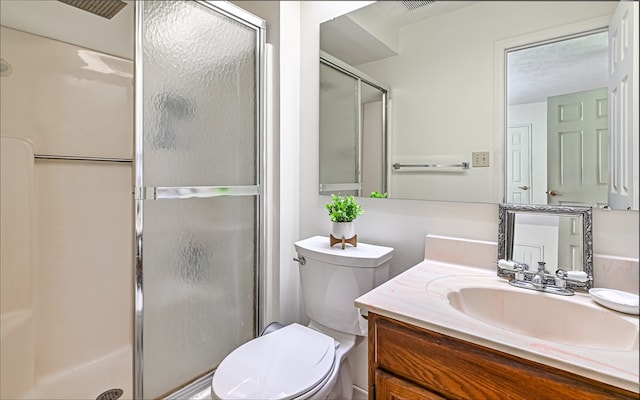 bathroom featuring vanity, toilet, and an enclosed shower