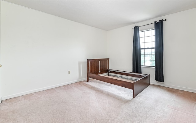 unfurnished bedroom featuring light carpet