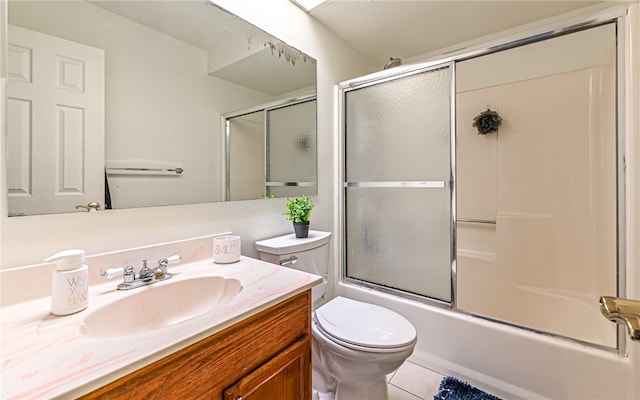 full bathroom with tile patterned flooring, bath / shower combo with glass door, vanity, and toilet