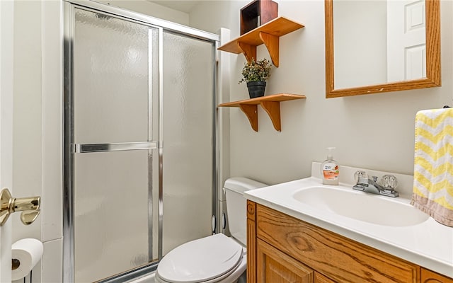 bathroom with a shower with shower door, vanity, and toilet