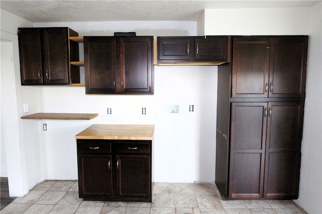 kitchen featuring dark brown cabinets and butcher block countertops