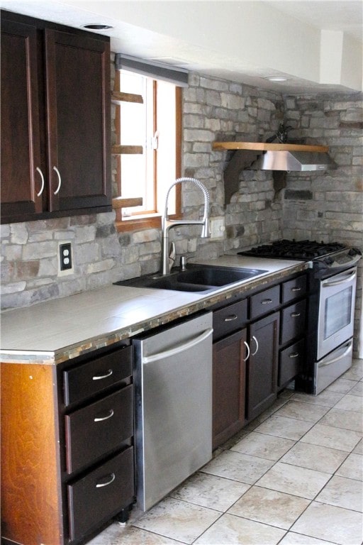 kitchen with dark brown cabinets, appliances with stainless steel finishes, backsplash, and sink