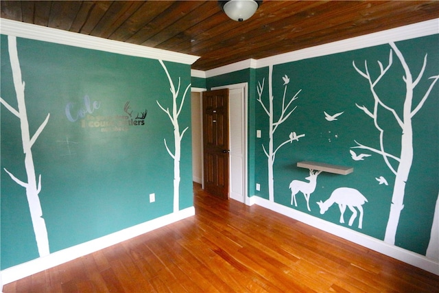 spare room featuring wooden ceiling, crown molding, and wood-type flooring