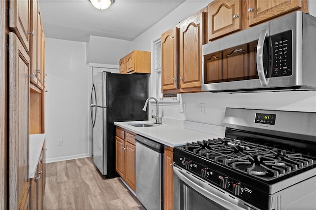 kitchen featuring light wood-type flooring, sink, and stainless steel appliances