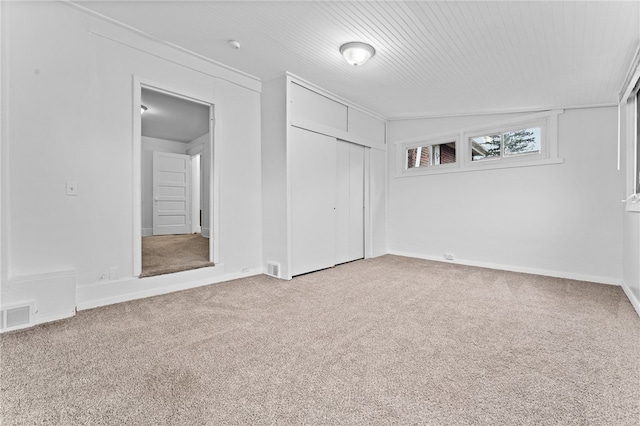 unfurnished bedroom with light colored carpet, a closet, and vaulted ceiling