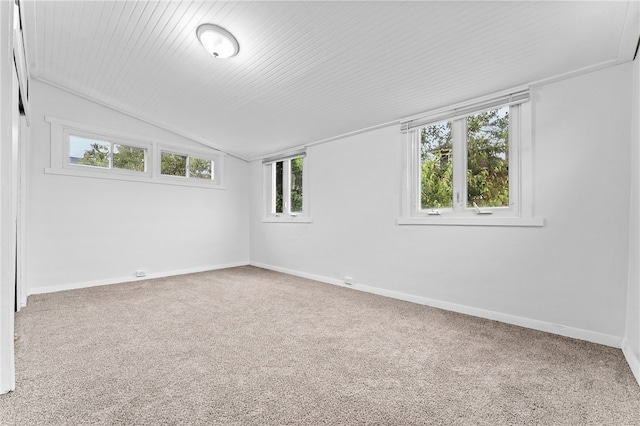 carpeted empty room with vaulted ceiling